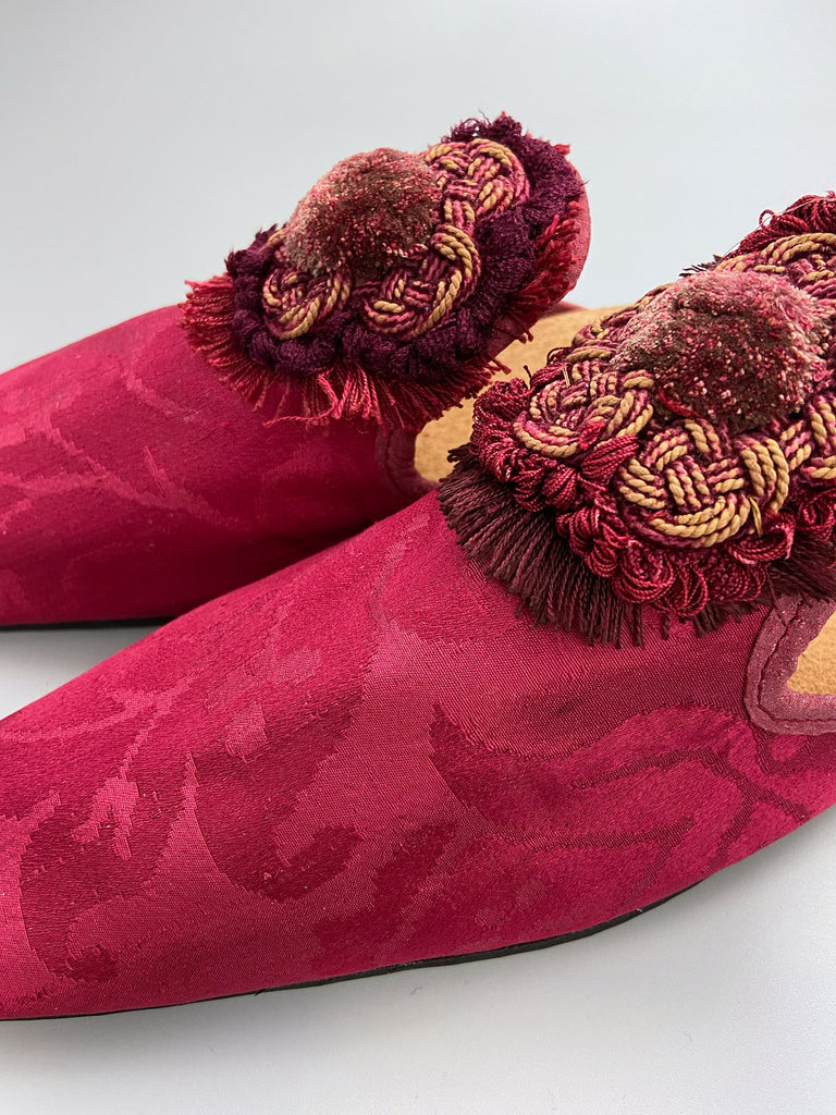 Raspberry red 19th century silk damask square toed backless slipper shoes with antique French passementerie silk chenille and cord medallion rosettes. Bohemian style created from antique textiles by the Pavilion Parade studio.