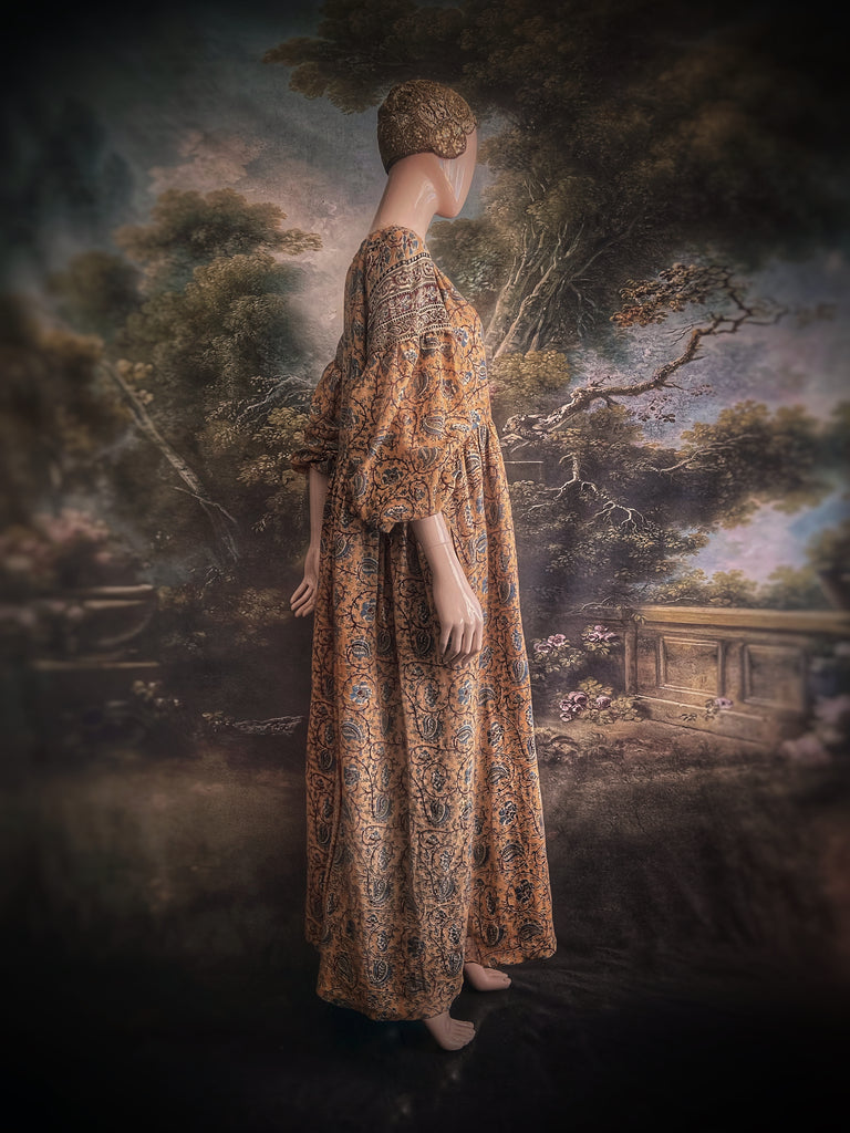 Faded ochre yellow and slate blue-grey cotton muslin block printed dress with long full sleeves and adjustable drawstring neckline. Bohemian styles sustainably created from antique and vintage textiles by the Pavilion Parade studio. 