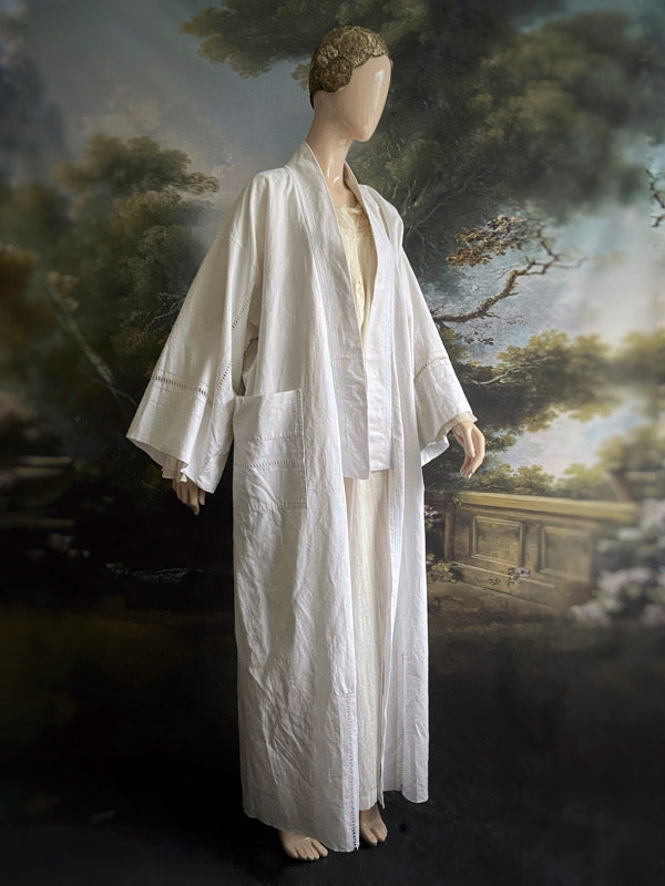 Full length kimono inspired robe with large patch pockets and wide sleeves. Created from an antique heavy French linen trousseau sheet with heirloom embroidery and drawn thread work. All French seamed with hand finished hems and collar. Bohemian styles sustainably created from antique and vintage textiles by the Pavilion Parade studio.
