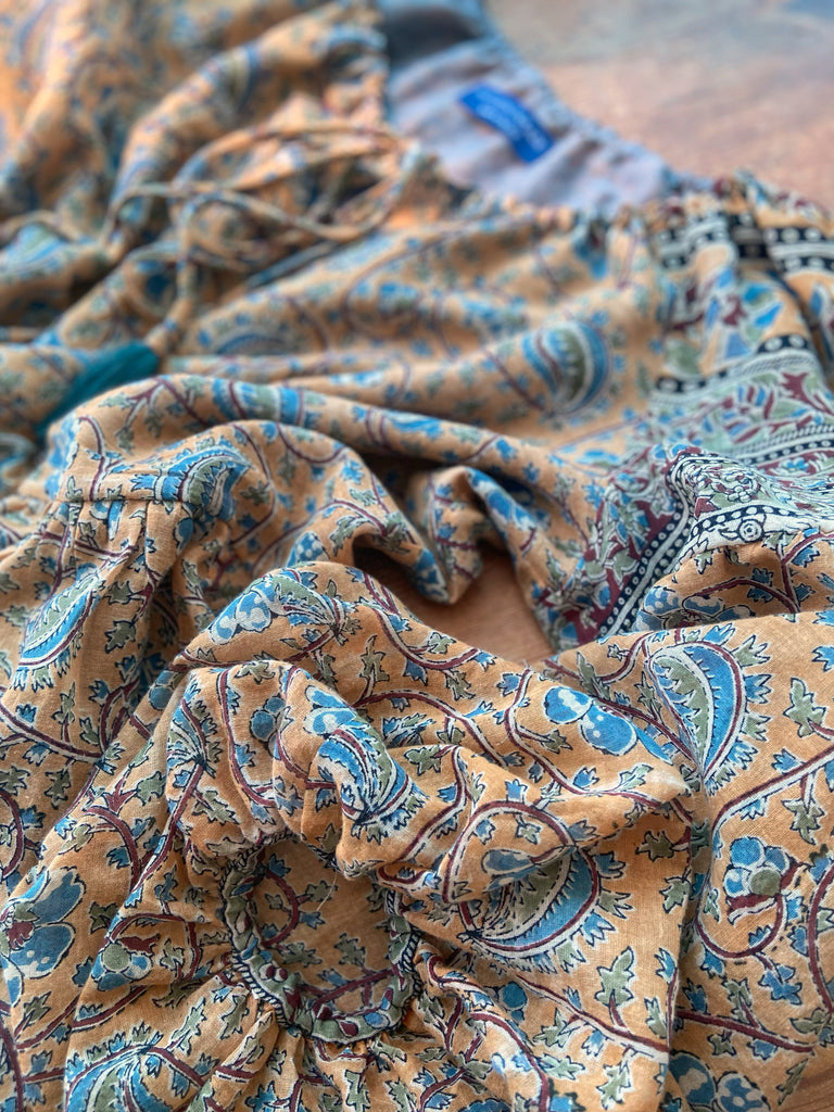 Faded ochre yellow and slate blue-grey cotton muslin block printed dress with long full sleeves and adjustable drawstring neckline. Bohemian styles sustainably created from antique and vintage textiles by the Pavilion Parade studio. 