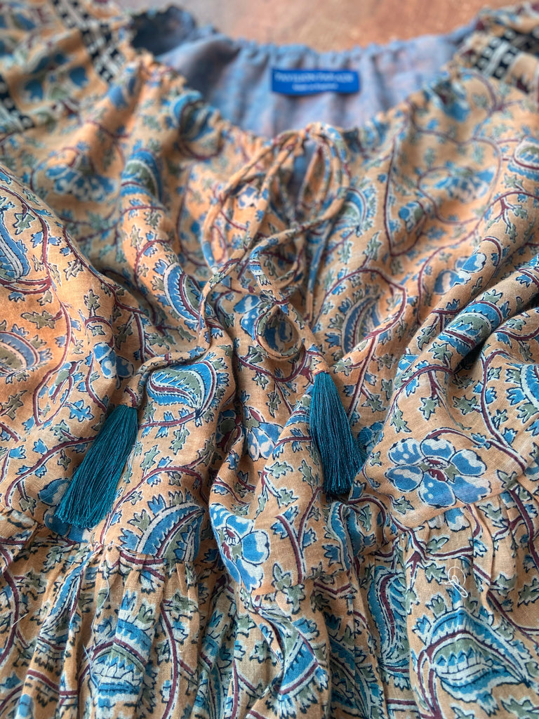 Faded ochre yellow and slate blue-grey cotton muslin block printed dress with long full sleeves and adjustable drawstring neckline. Bohemian styles sustainably created from antique and vintage textiles by the Pavilion Parade studio. 