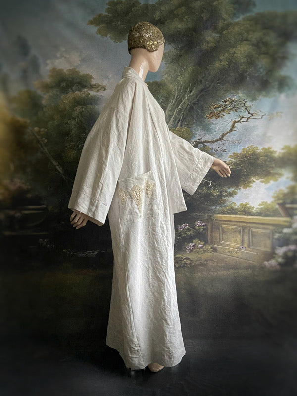 Full length kimono inspired robe with large patch pockets and wide sleeves. Created from an antique heavy French linen trousseau sheet with heirloom embroidery and drawn thread work. All French seamed with hand finished hems and collar. Bohemian styles sustainably created from antique and vintage textiles by the Pavilion Parade studio.
