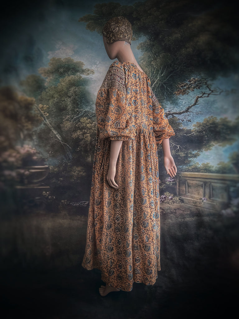 Faded ochre yellow and slate blue-grey cotton muslin block printed dress with long full sleeves and adjustable drawstring neckline. Bohemian styles sustainably created from antique and vintage textiles by the Pavilion Parade studio. 