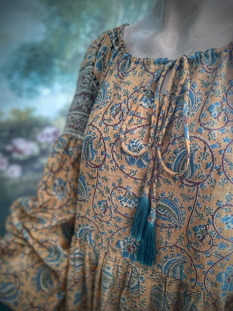 Faded ochre yellow and slate blue-grey cotton muslin block printed dress with long full sleeves and adjustable drawstring neckline. Bohemian styles sustainably created from antique and vintage textiles by the Pavilion Parade studio. 