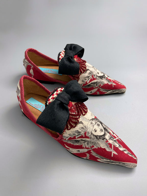 Red, black and white pointed toe bohemian shoes or slippers with a neo-classical winged god motif. Large black silk ribbon bows. Created from antique textiles by Pavilion Parade