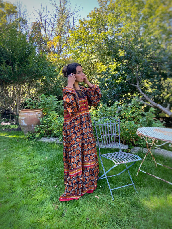 Black, burnt orange, and chilli red silk georgette maxi dress with tassel drawstring neckline, long full sleeves and side pockets. Bohemian style sustainably created from vintage and antique textiles by the Pavilion Parade studio.