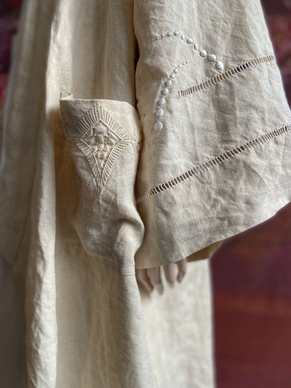 Full length kimono inspired robe with large patch pockets and wide sleeves. Created from an antique heavy French linen trousseau sheet with heirloom embroidery and drawn thread work. All French seamed with hand finished hems and collar. Bohemian styles sustainably created from antique and vintage textiles by the Pavilion Parade studio.
