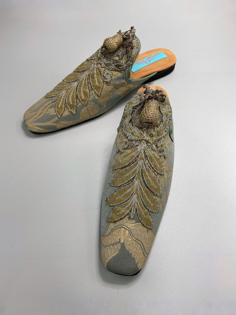 French grey silk brocade and 19th century metallic silver lace are used to create bohemian style shoes with hand worked antique acorn embellishment. Unique style by the Pavilion Parade studio.