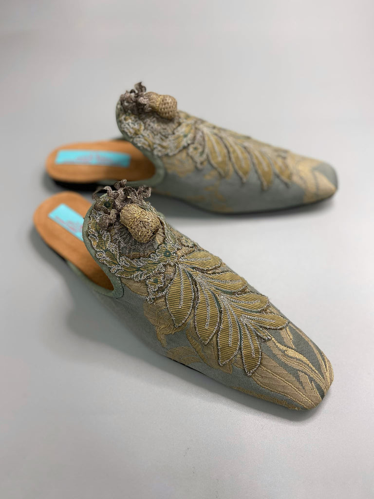 French grey silk brocade and 19th century metallic silver lace are used to create bohemian style shoes with hand worked antique acorn embellishment. Unique style by the Pavilion Parade studio.