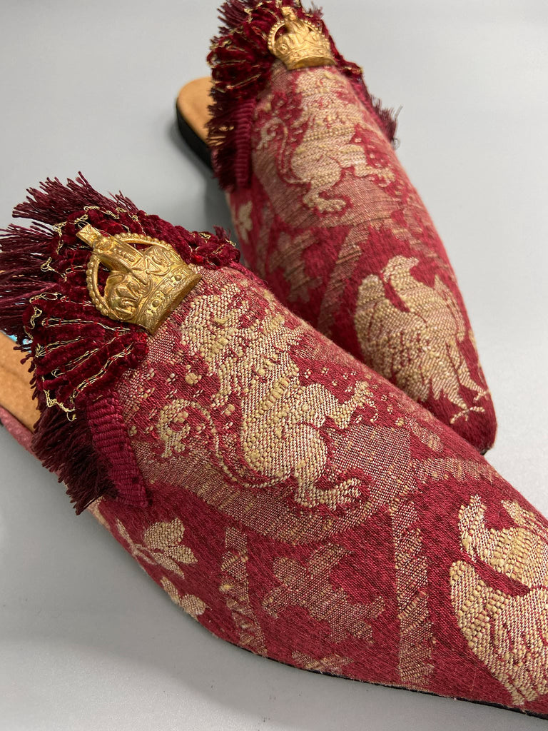 Dark red French brocade slipper shoes with a heraldic design of lions rampant, embellished with early 1800s Florentine silk tassel fringe and aged toleware crowns. Created from antique textiles by Pavilion Parade