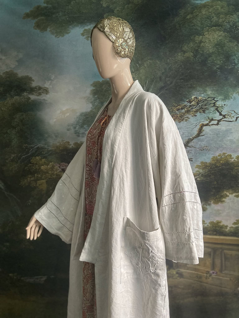 Full length kimono inspired robe with large patch pockets and wide sleeves. Created from an antique heavy French linen trousseau sheet with heirloom embroidery and drawn thread work. All French seamed with hand finished hems and collar. Bohemian styles sustainably created from antique and vintage textiles by the Pavilion Parade studio.