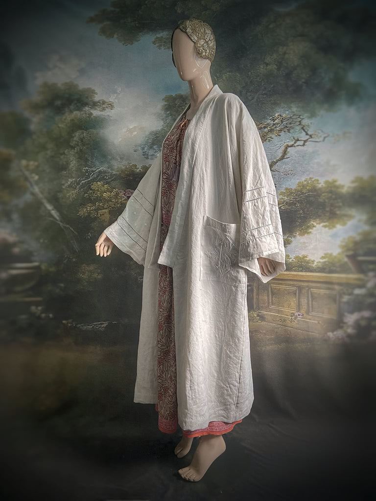 Full length kimono inspired robe with large patch pockets and wide sleeves. Created from an antique heavy French linen trousseau sheet with heirloom embroidery and drawn thread work. All French seamed with hand finished hems and collar. Bohemian styles sustainably created from antique and vintage textiles by the Pavilion Parade studio.