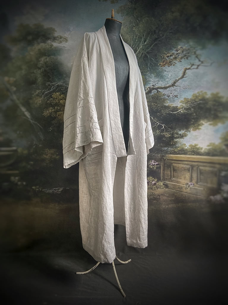 Full length kimono inspired robe with large patch pockets and wide sleeves. Created from an antique heavy French linen trousseau sheet with heirloom embroidery and drawn thread work. All French seamed with hand finished hems and collar. Bohemian styles sustainably created from antique and vintage textiles by the Pavilion Parade studio.