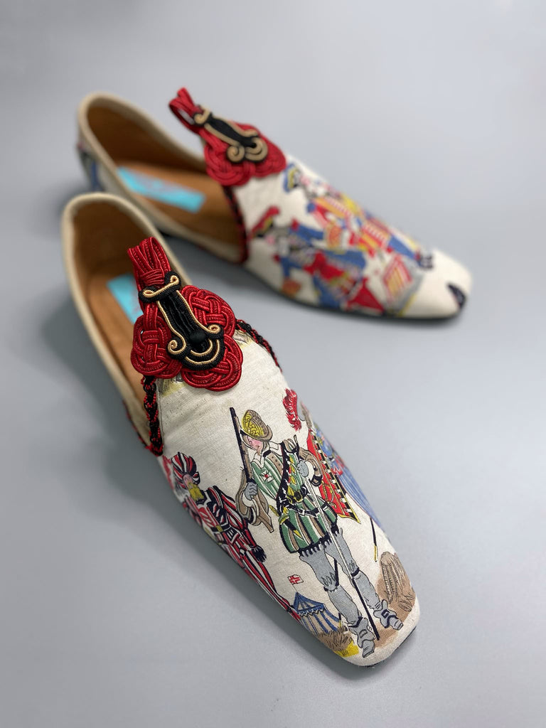 Historic military uniformed soldiers from a vintage French printed toile, and scarlet soutache frogging are used to create unique bohemian shoes by Pavilion Parade