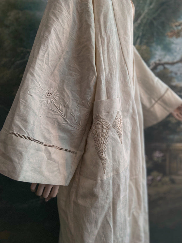 Full length kimono inspired robe with large patch pockets and wide sleeves. Created from an antique heavy French linen trousseau sheet with heirloom embroidery and drawn thread work. All French seamed with hand finished hems and collar. Bohemian styles sustainably created from antique and vintage textiles by the Pavilion Parade studio.
