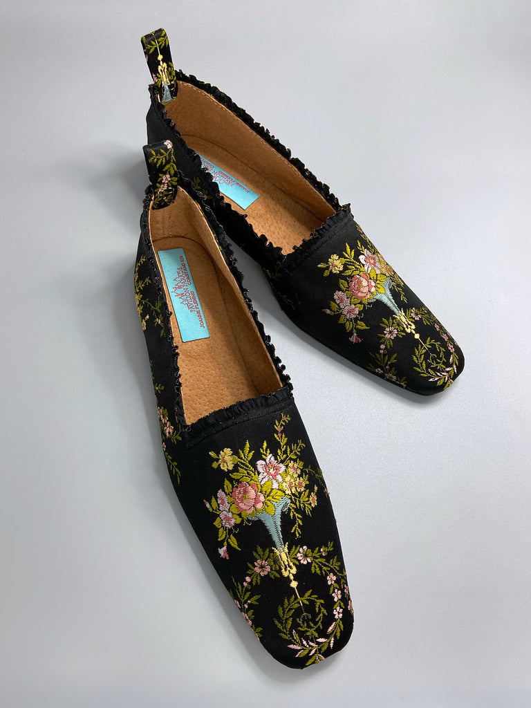 Black silk regency slipper shoes with floral embroidered posy motif. Squared toes and black silk satin ankle ribbons. Bohemian style created from antique textiles by the Pavilion Parade studio.