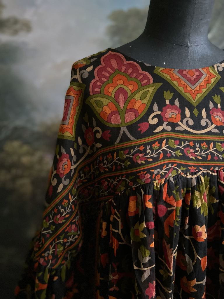 Vibrant Indian floral on black fine cotton muslin bohemian dress with full sleeves and pockets. Created from antique and vintage textiles by the Pavilion Parade studio