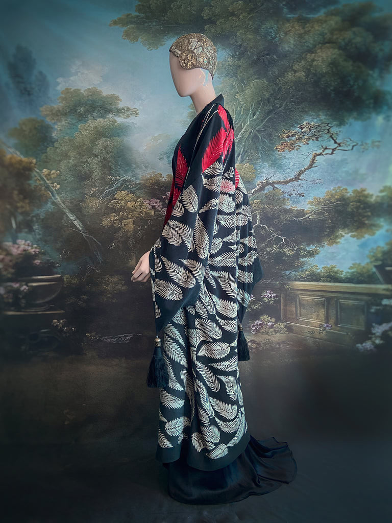 Full length 1920s inspired kimono robe with large patch pockets. Newly created from a crimson red and kohl black block print feather vintage crepe. Antique silk fringe on collar and large weighted tassels on sleeves. Fully lined in silk with French seams throughout. Bohemian styles sustainably created from antique and vintage textiles by the Pavilion Parade studio.