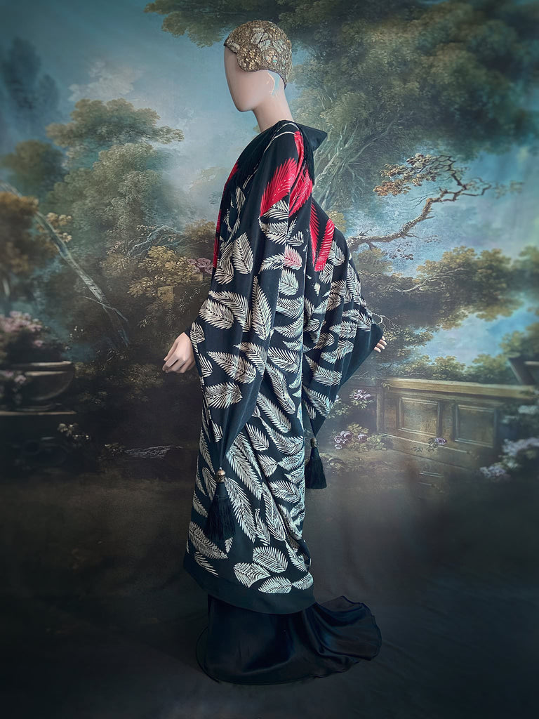 Full length 1920s inspired kimono robe with large patch pockets. Newly created from a crimson red and kohl black block print feather vintage crepe. Antique silk fringe on collar and large weighted tassels on sleeves. Fully lined in silk with French seams throughout. Bohemian styles sustainably created from antique and vintage textiles by the Pavilion Parade studio.