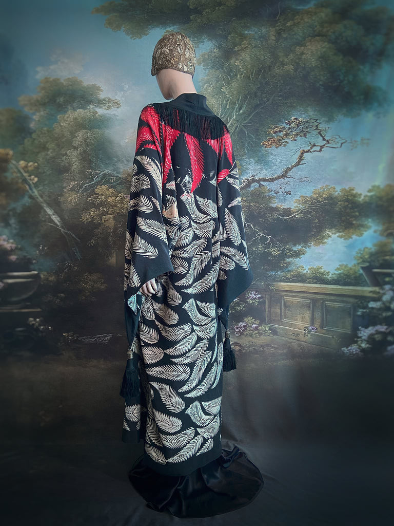 Full length 1920s inspired kimono robe with large patch pockets. Newly created from a crimson red and kohl black block print feather vintage crepe. Antique silk fringe on collar and large weighted tassels on sleeves. Fully lined in silk with French seams throughout. Bohemian styles sustainably created from antique and vintage textiles by the Pavilion Parade studio.