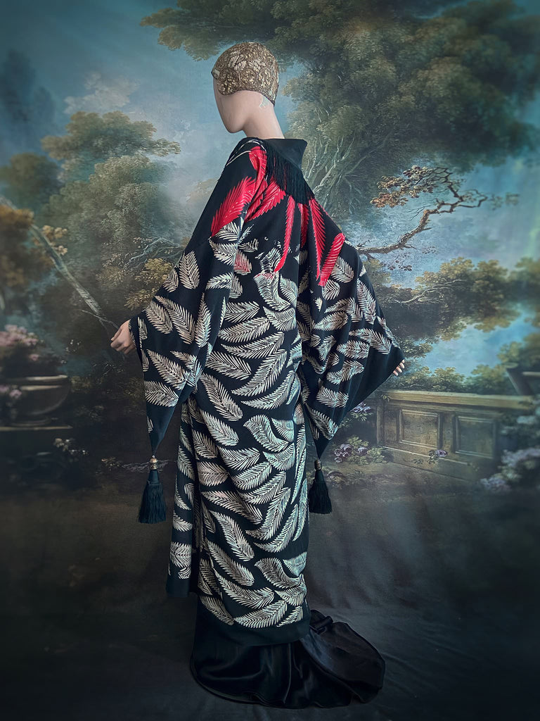 Full length 1920s inspired kimono robe with large patch pockets. Newly created from a crimson red and kohl black block print feather vintage crepe. Antique silk fringe on collar and large weighted tassels on sleeves. Fully lined in silk with French seams throughout. Bohemian styles sustainably created from antique and vintage textiles by the Pavilion Parade studio.
