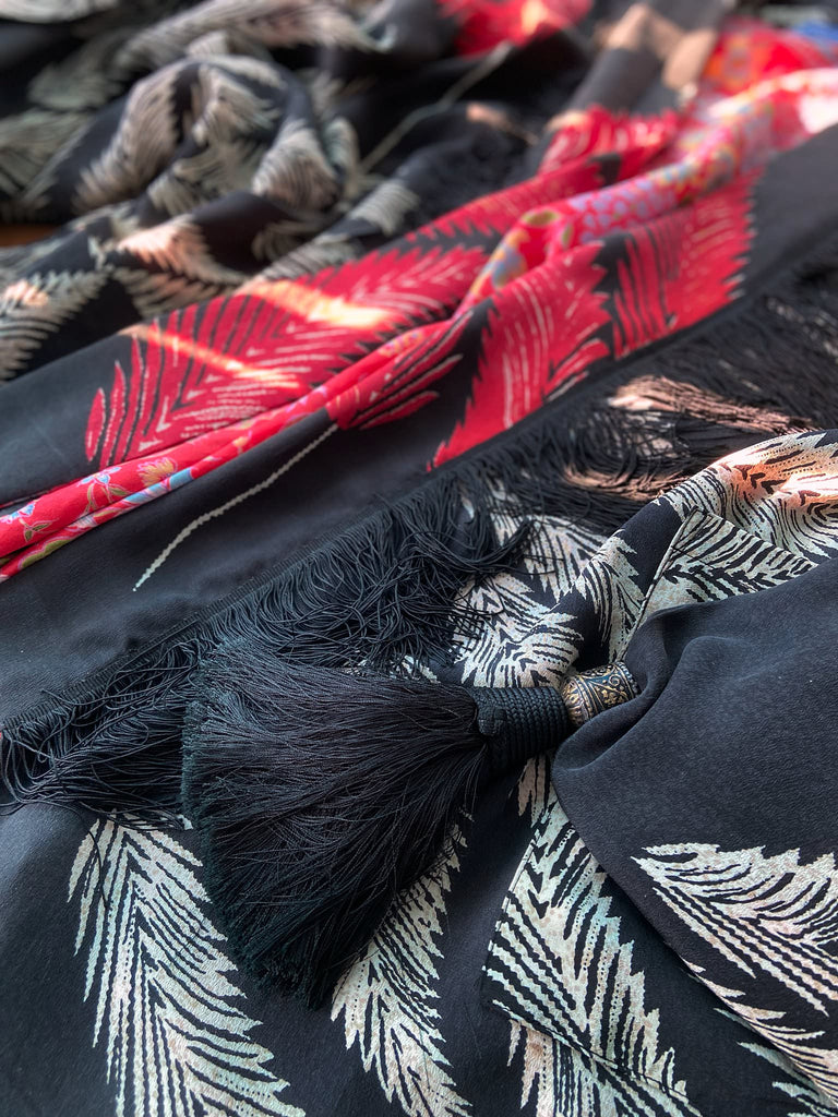 Full length 1920s inspired kimono robe with large patch pockets. Newly created from a crimson red and kohl black block print feather vintage crepe. Antique silk fringe on collar and large weighted tassels on sleeves. Fully lined in silk with French seams throughout. Bohemian styles sustainably created from antique and vintage textiles by the Pavilion Parade studio.