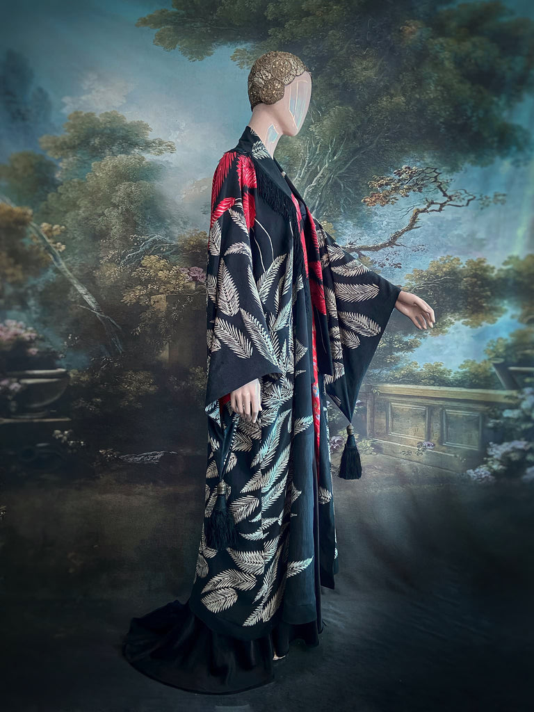 Full length 1920s inspired kimono robe with large patch pockets. Newly created from a crimson red and kohl black block print feather vintage crepe. Antique silk fringe on collar and large weighted tassels on sleeves. Fully lined in silk with French seams throughout. Bohemian styles sustainably created from antique and vintage textiles by the Pavilion Parade studio.