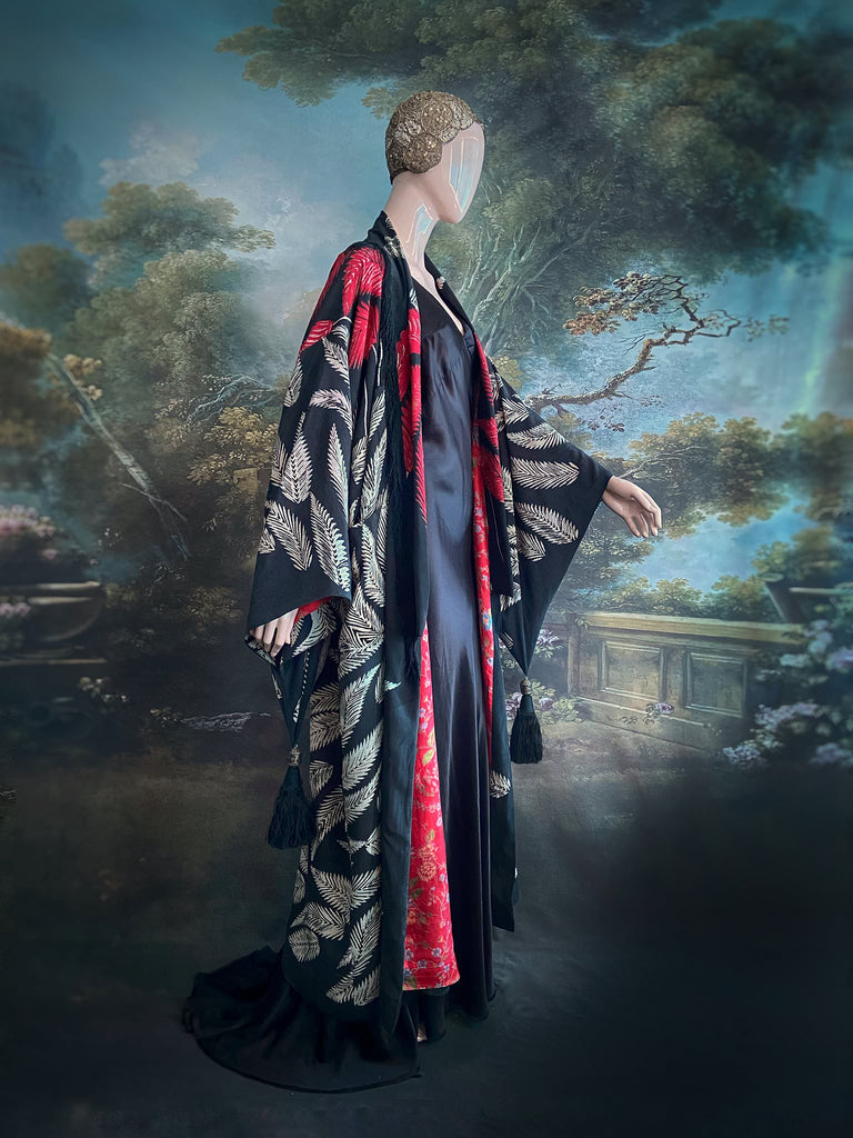 Full length 1920s inspired kimono robe with large patch pockets. Newly created from a crimson red and kohl black block print feather vintage crepe. Antique silk fringe on collar and large weighted tassels on sleeves. Fully lined in silk with French seams throughout. Bohemian styles sustainably created from antique and vintage textiles by the Pavilion Parade studio.