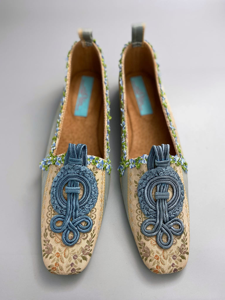 Pale blue and ivory silk brocade Regency inspired dancing slippers with rococo ribbon trim. Embellished with dusty blue antique soutache cord medallions. Bohemian styles created from antique textiles by the Pavilion Parade studio. 