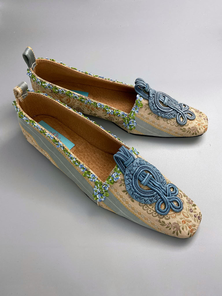 Pale blue and ivory silk brocade Regency inspired dancing slippers with rococo ribbon trim. Embellished with dusty blue antique soutache cord medallions. Bohemian styles created from antique textiles by the Pavilion Parade studio. 