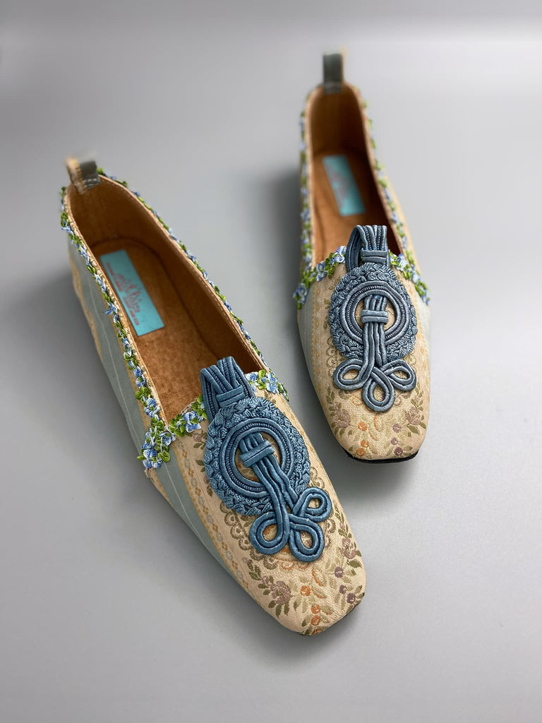Pale blue and ivory silk brocade Regency inspired dancing slippers with rococo ribbon trim. Embellished with dusty blue antique soutache cord medallions. Bohemian styles created from antique textiles by the Pavilion Parade studio. 