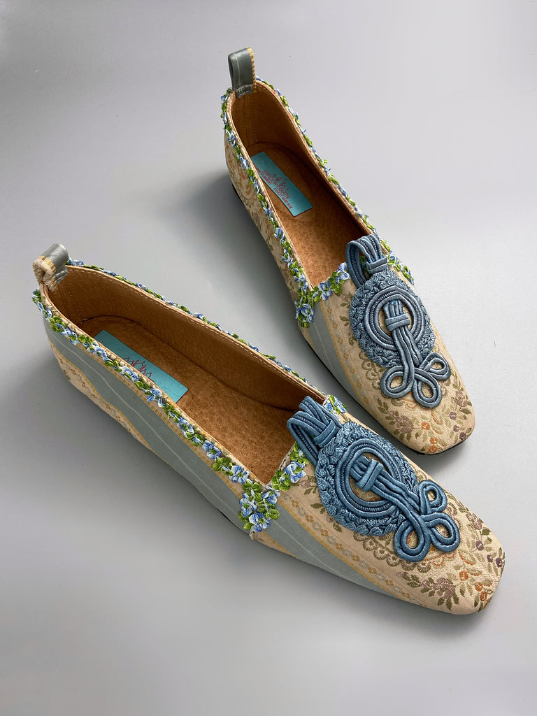 Pale blue and ivory silk brocade Regency inspired dancing slippers with rococo ribbon trim. Embellished with dusty blue antique soutache cord medallions. Bohemian styles created from antique textiles by the Pavilion Parade studio. 