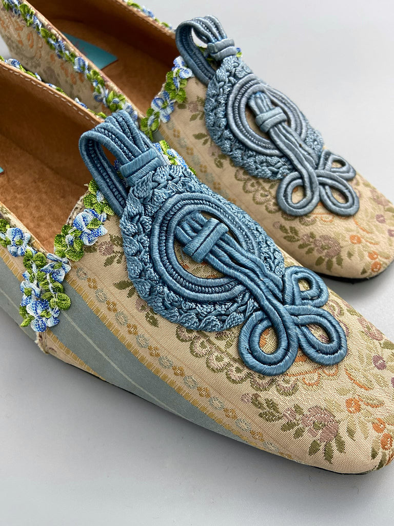 Pale blue and ivory silk brocade Regency inspired dancing slippers with rococo ribbon trim. Embellished with dusty blue antique soutache cord medallions. Bohemian styles created from antique textiles by the Pavilion Parade studio. 