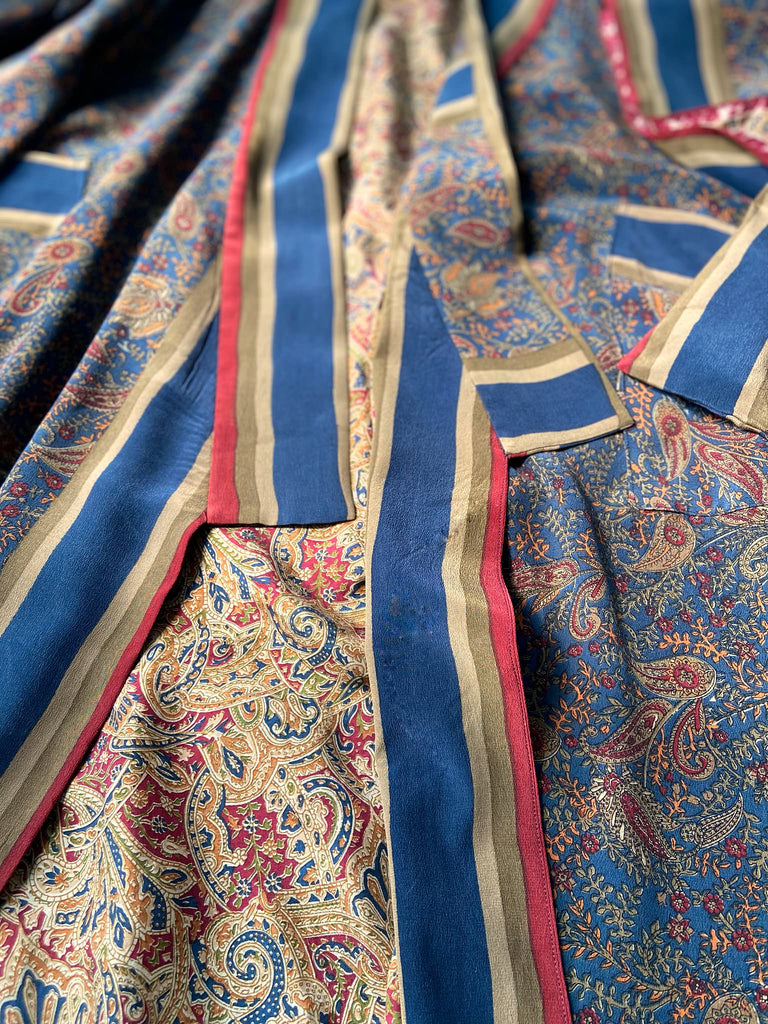 Full length 1920s inspired kimono robe with large patch pockets. Newly created from a blue, red and pumpkin vintage silk crepe. Fully lined in silk with French seams throughout. Bohemian styles sustainably created from antique and vintage textiles by the Pavilion Parade studio.