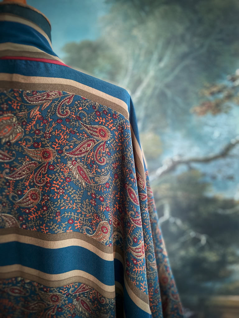 Full length 1920s inspired kimono robe with large patch pockets. Newly created from a blue, red and pumpkin vintage silk crepe. Fully lined in silk with French seams throughout. Bohemian styles sustainably created from antique and vintage textiles by the Pavilion Parade studio.