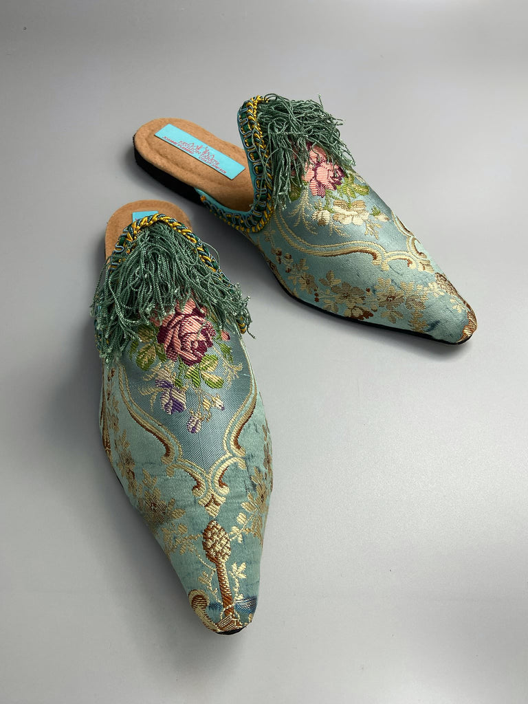 Faded sky blue silk pointed toe shoes with pink roses in the Georgian style. Embellished with silk tassel fringe and antique braids. Bohemian styles sustainably created from antique textiles by Pavilion Parade.