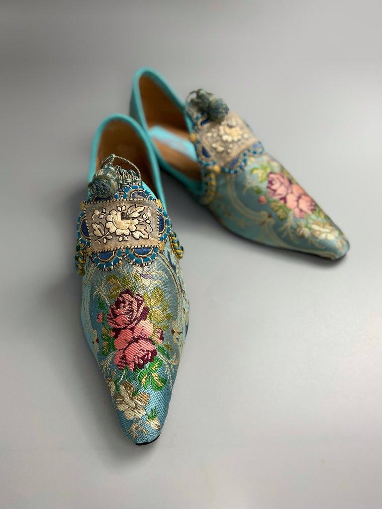 Faded sky blue silk pointed toe shoes with pink roses in the Georgian style. Embellished with silk embroidered appliqués and antique braids. Bohemian styles sustainably created from antique textiles by Pavilion Parade.