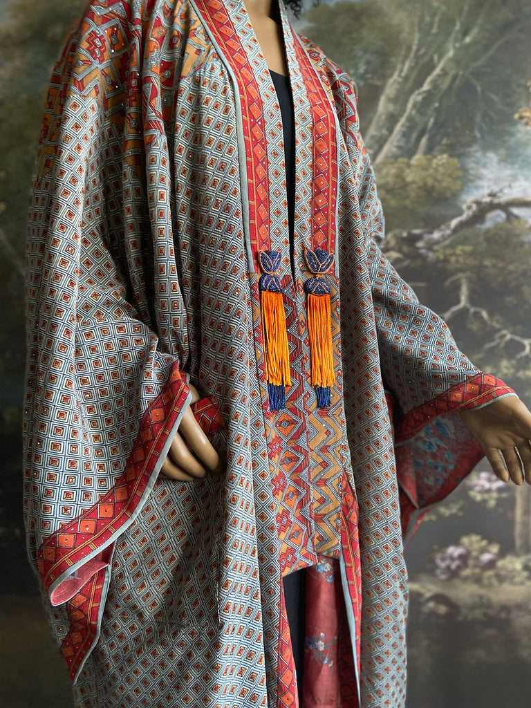 Full length 1920s inspired kimono robe with large patch pockets and antique Art Deco beaded tassels. Newly created from a dusty slate blue, rust and mustard vintage silk crepe with silver wire Mukesh work detail. Fully lined in silk with French seams throughout. Bohemian styles sustainably created from antique and vintage textiles by the Pavilion Parade studio.