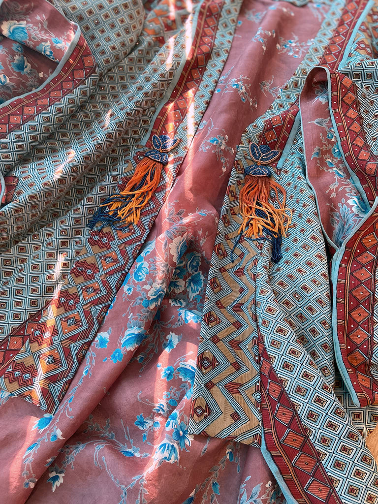 Full length 1920s inspired kimono robe with large patch pockets and antique Art Deco beaded tassels. Newly created from a dusty slate blue, rust and mustard vintage silk crepe with silver wire Mukesh work detail. Fully lined in silk with French seams throughout. Bohemian styles sustainably created from antique and vintage textiles by the Pavilion Parade studio.