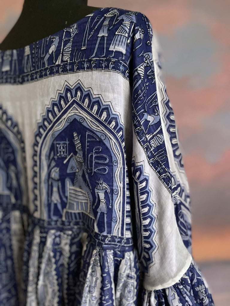 Blue and off white cotton voile dress with Ancient Egyptian heiroglyph motifs. Long full sleeves, ankle length with pockets. Fully reversible to a Delft china blue and ivory paisley Indian muslin. Bohemian style sustainably created from vintage and antique textiles by the Pavilion Parade studio.
