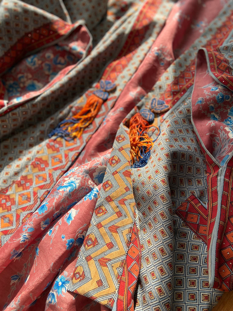 Full length 1920s inspired kimono robe with large patch pockets and antique Art Deco beaded tassels. Newly created from a dusty slate blue, rust and mustard vintage silk crepe with silver wire Mukesh work detail. Fully lined in silk with French seams throughout. Bohemian styles sustainably created from antique and vintage textiles by the Pavilion Parade studio.