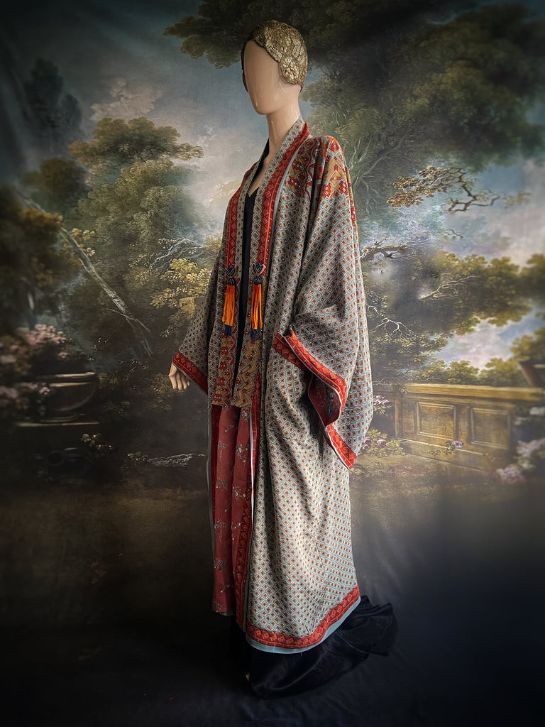 Full length 1920s inspired kimono robe with large patch pockets and antique Art Deco beaded tassels. Newly created from a dusty slate blue, rust and mustard vintage silk crepe with silver wire Mukesh work detail. Fully lined in silk with French seams throughout. Bohemian styles sustainably created from antique and vintage textiles by the Pavilion Parade studio.