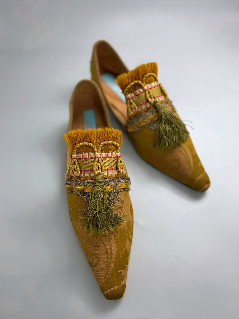 Bronze silk damask pointed toe shoes embellished with ochre fringing, metallic braids and olive green silk tassels. Bohemian style from the Pavilion Parade studio.
