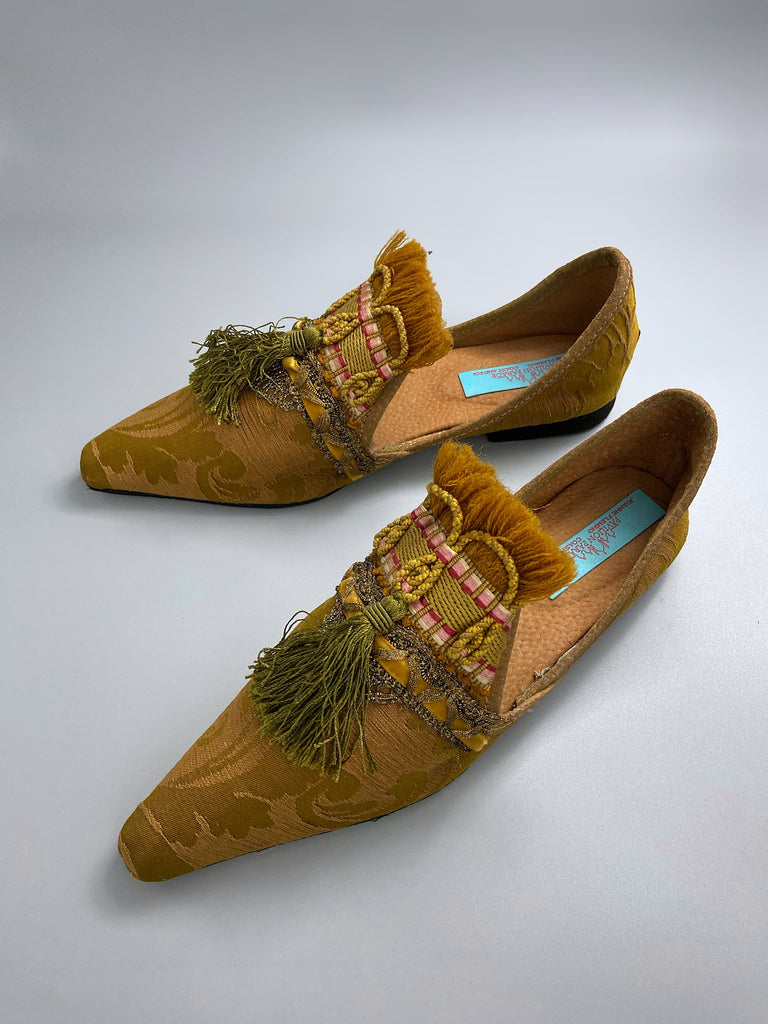 Bronze silk damask pointed toe shoes embellished with ochre fringing, metallic braids and olive green silk tassels. Bohemian style from the Pavilion Parade studio.
