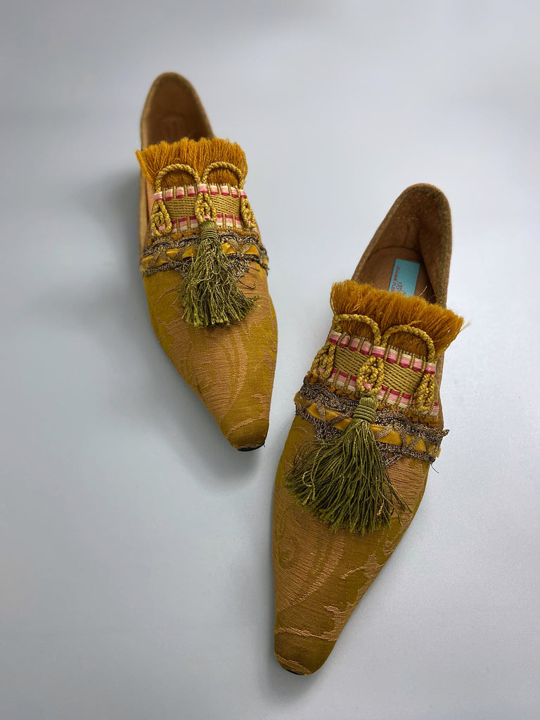 Bronze silk damask pointed toe shoes embellished with ochre fringing, metallic braids and olive green silk tassels. Bohemian style from the Pavilion Parade studio.