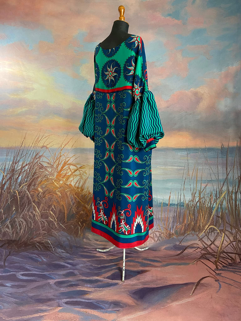 Silk crepe shift dress with pockets and volume long sleeves gathered in to fitted cuffs. Bold grphic print in shades of cobalt blue, teal and scarlet.  Unique garments sustainably created from vintage textiles by the Pavilion Parade studio.