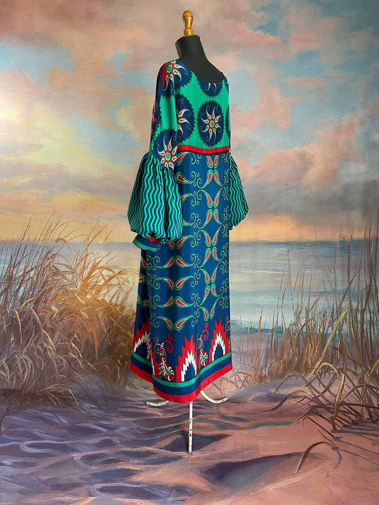 Silk crepe shift dress with pockets and volume long sleeves gathered in to fitted cuffs. Bold grphic print in shades of cobalt blue, teal and scarlet.  Unique garments sustainably created from vintage textiles by the Pavilion Parade studio.