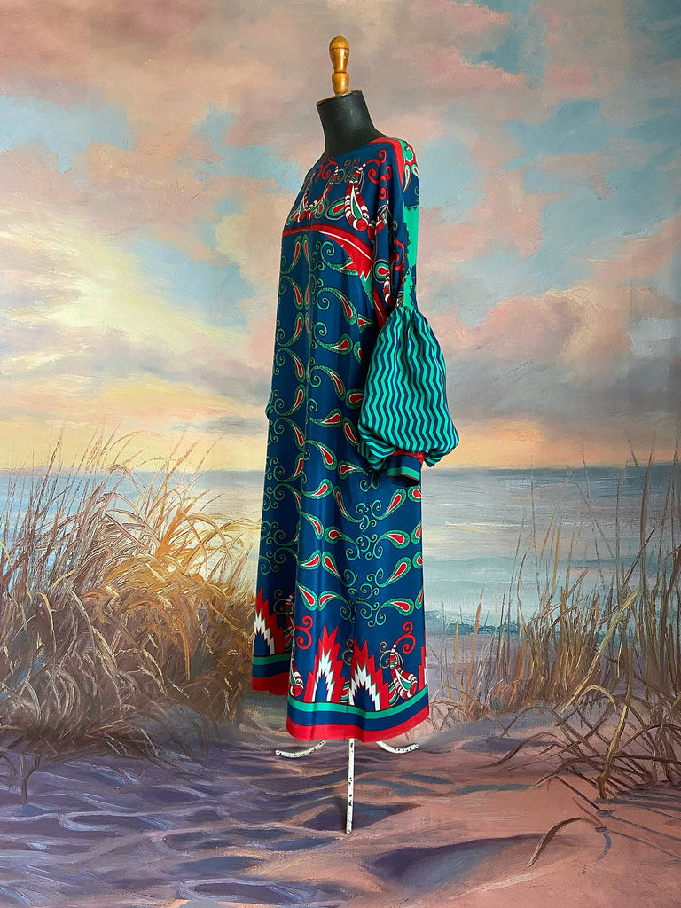 Silk crepe shift dress with pockets and volume long sleeves gathered in to fitted cuffs. Bold grphic print in shades of cobalt blue, teal and scarlet.  Unique garments sustainably created from vintage textiles by the Pavilion Parade studio.