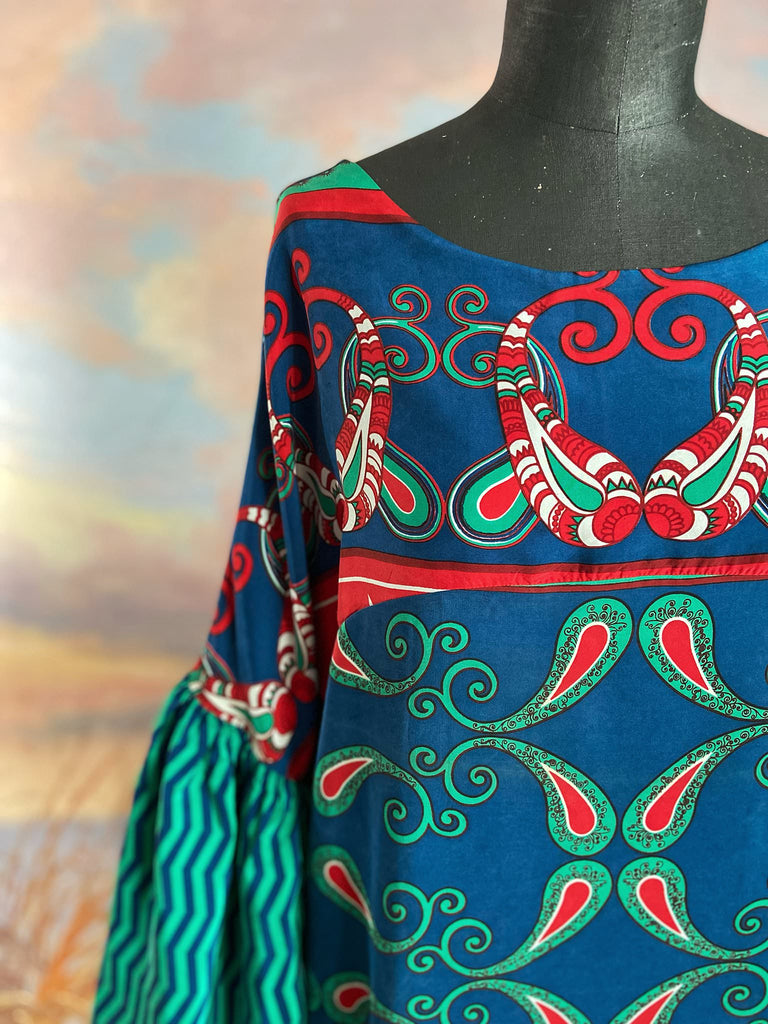 Silk crepe shift dress with pockets and volume long sleeves gathered in to fitted cuffs. Bold grphic print in shades of cobalt blue, teal and scarlet.  Unique garments sustainably created from vintage textiles by the Pavilion Parade studio.