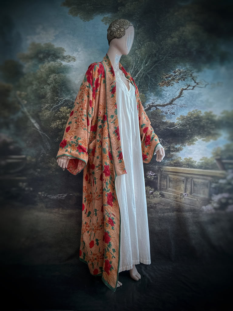 Full length 1920s 1930s Deco inspired kimono robe with large patch pockets. Newly created from a peach and mint green block print rose vintage silk crepe. Kimono collar and wide sleeves. Fully lined in silk with French seams throughout. Bohemian styles sustainably created from antique and vintage textiles by the Pavilion Parade studio.